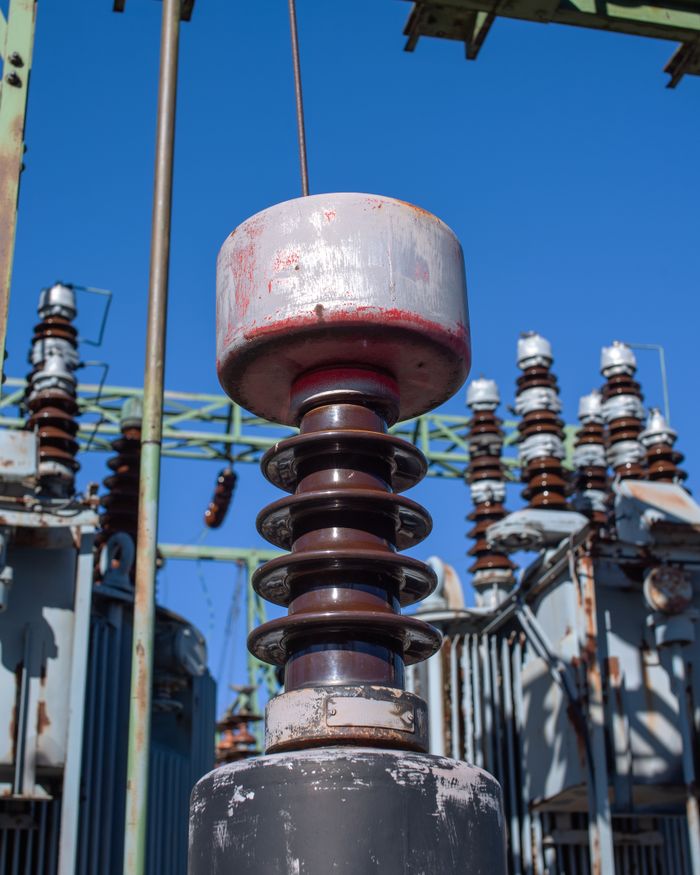 Close-up of high-voltage electrical insulator equipment at a utility substation in Helsinki, Finland.